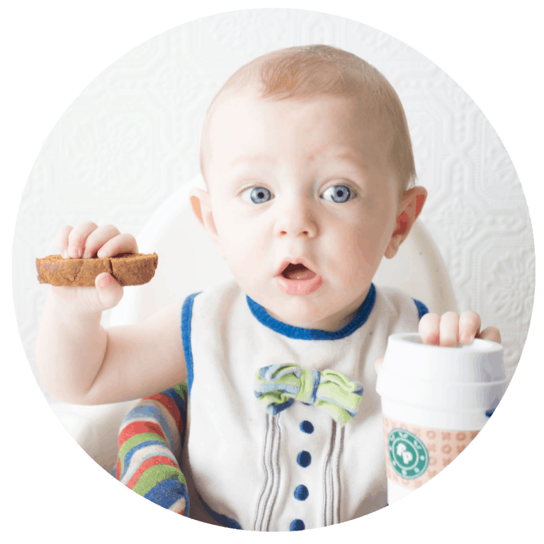 Baby holding pumpkin spice biscotti with Fisher Price Coffee Cup teething toy