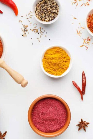 bowls of indian spices on a white background