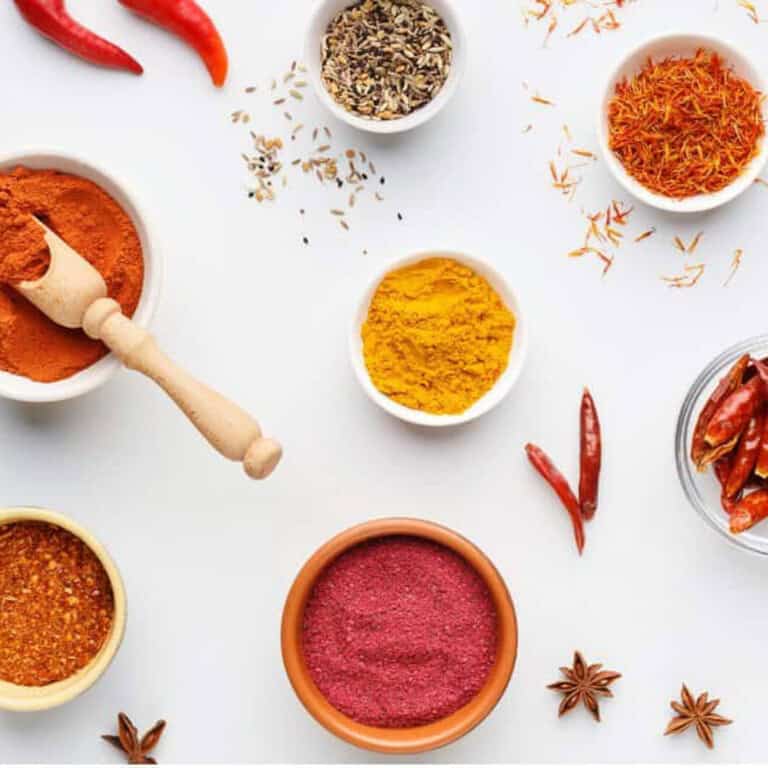 bowls of indian spices on a white background