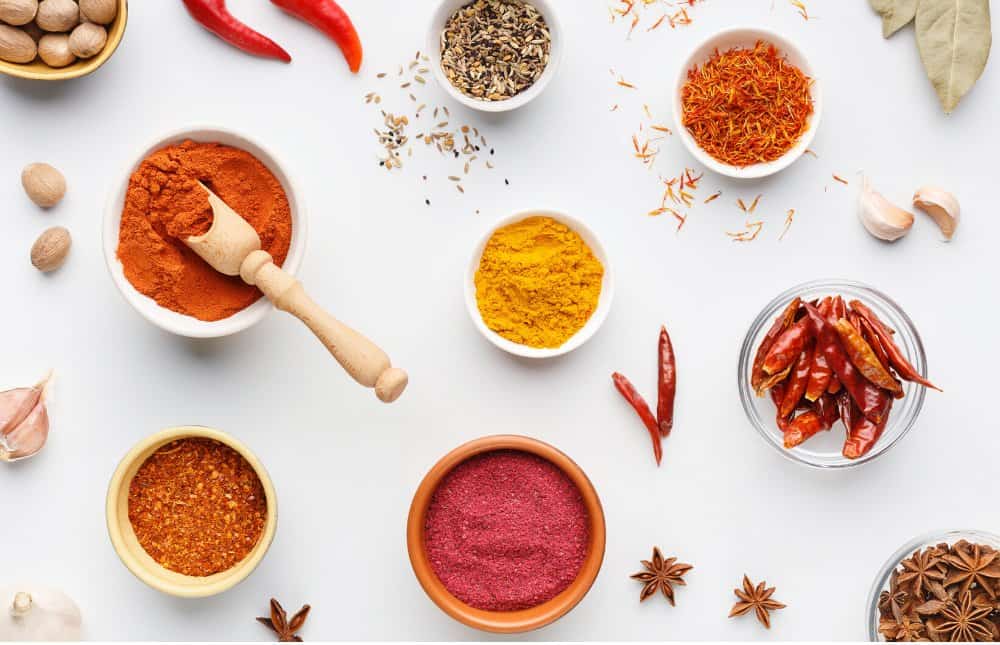 bowls of indian spices on a white background