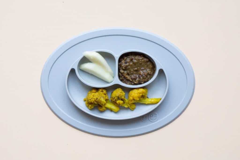 Balanced baby plate with indian food: daal, aloo gobi, and pear slices