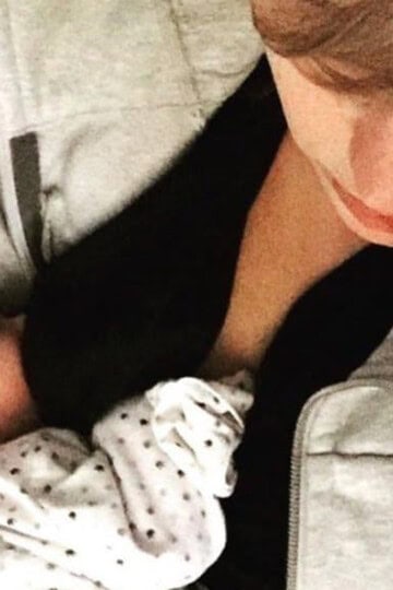 mother breasting her baby and holding him