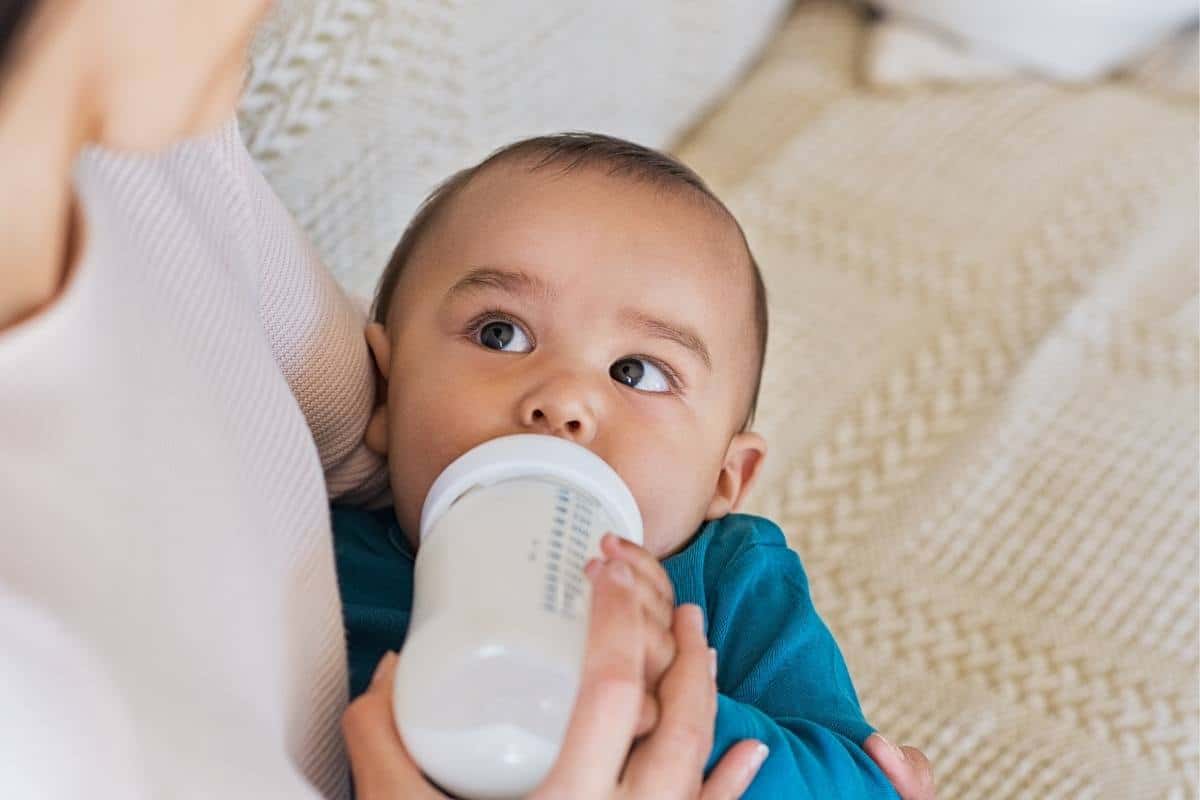 a mother holding her baby feeding him a bottle