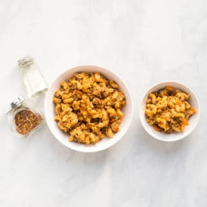 A side by side image of homemade hamburger helper. The bowl on the left is suitable for the family while the bowl on the right is suitable for baby.