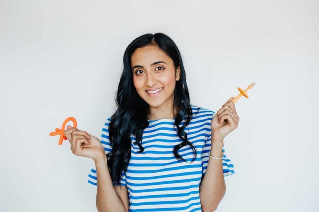 Nita Sharda, Registered Dietitian, holding up two teethers 