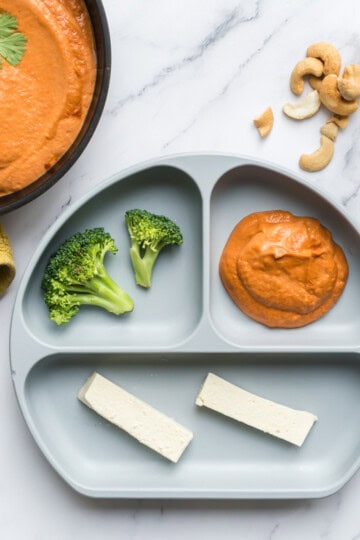 dairy free cashew korma sauce served to a baby with steamed broccoli and tofu