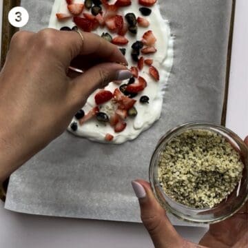 Sprinkling hemp hearts onto yogurt to make yogurt bark for babies.