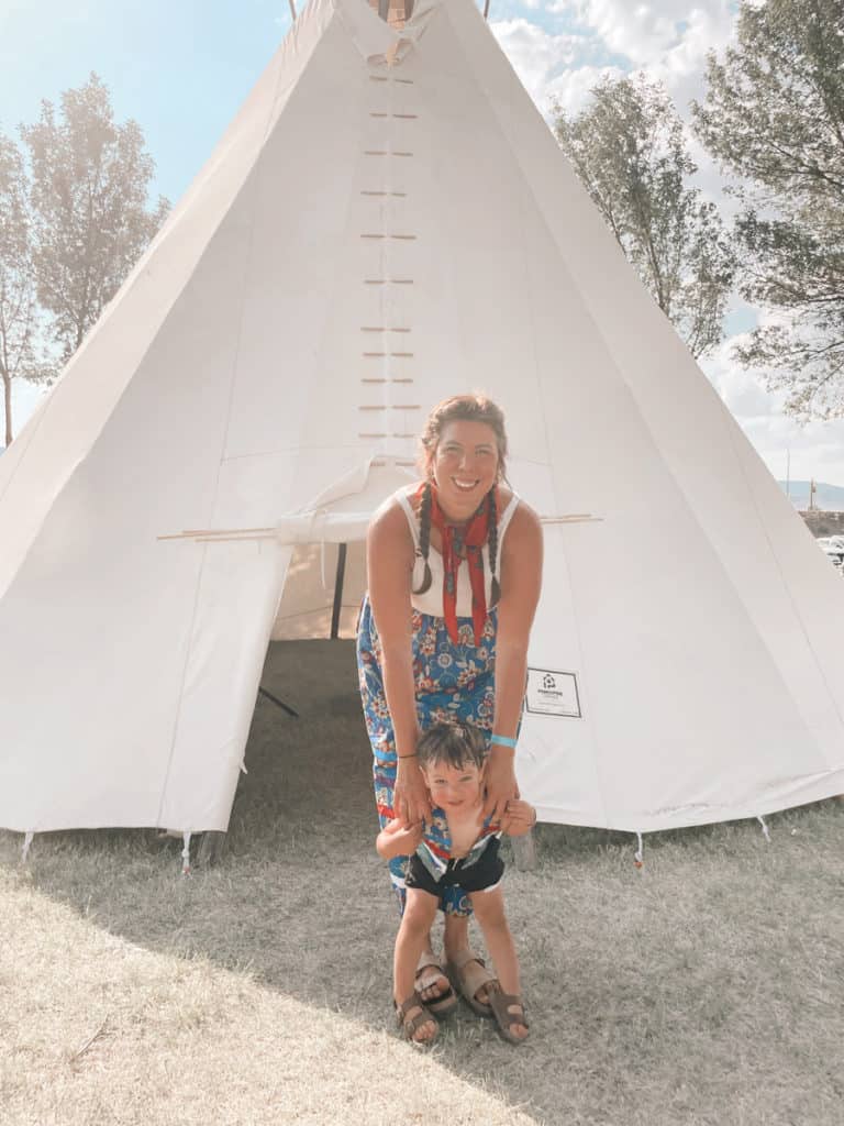 Sarah-Annde Gusdal with child in front of tipi