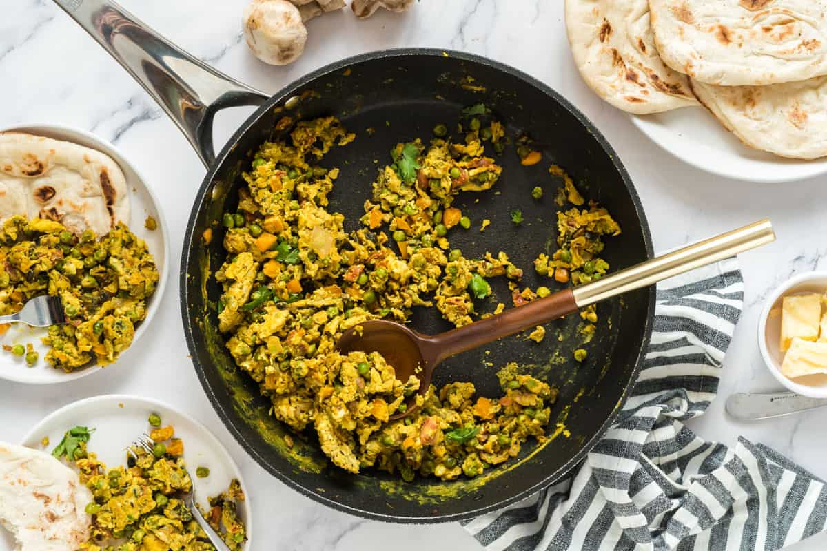 anda bhurji recipe for baby pictured in a frying pan and on plates with naan bread alongside ghee