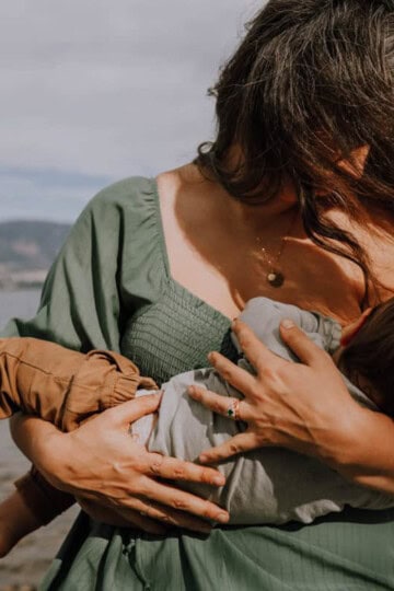 mother breastfeeding baby at beach