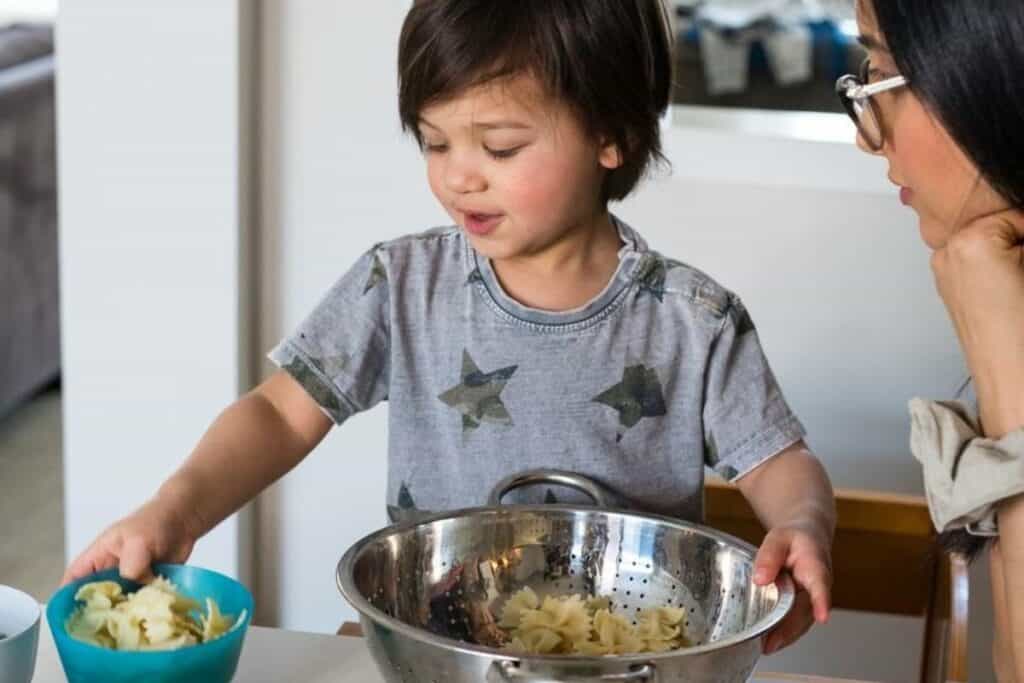 Toddler helping to make a pasta salad