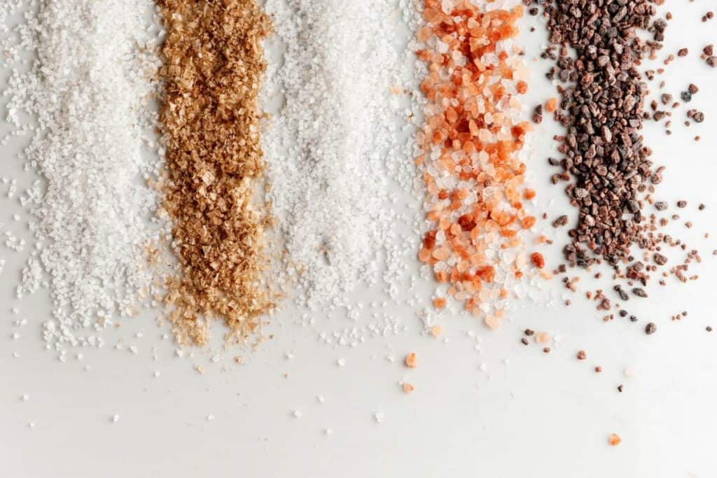 various types of salt spread out on a white background