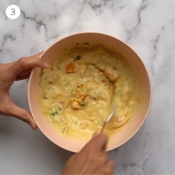 Image of a hand that is stirring ingredients together. 