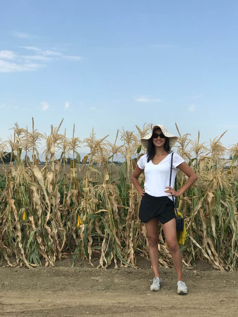 Nita Sharda standing in front of a corn field.
