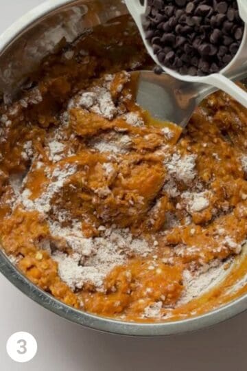 Bowl of wet and dry ingredients for the recipe being combine and chocolate chips being folded it