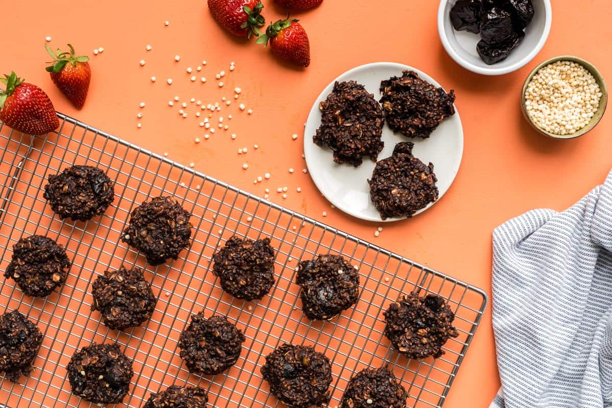 A cooling rack of healthy toddler breakfast cookies beside a plate of cookies garnished with strawberries.