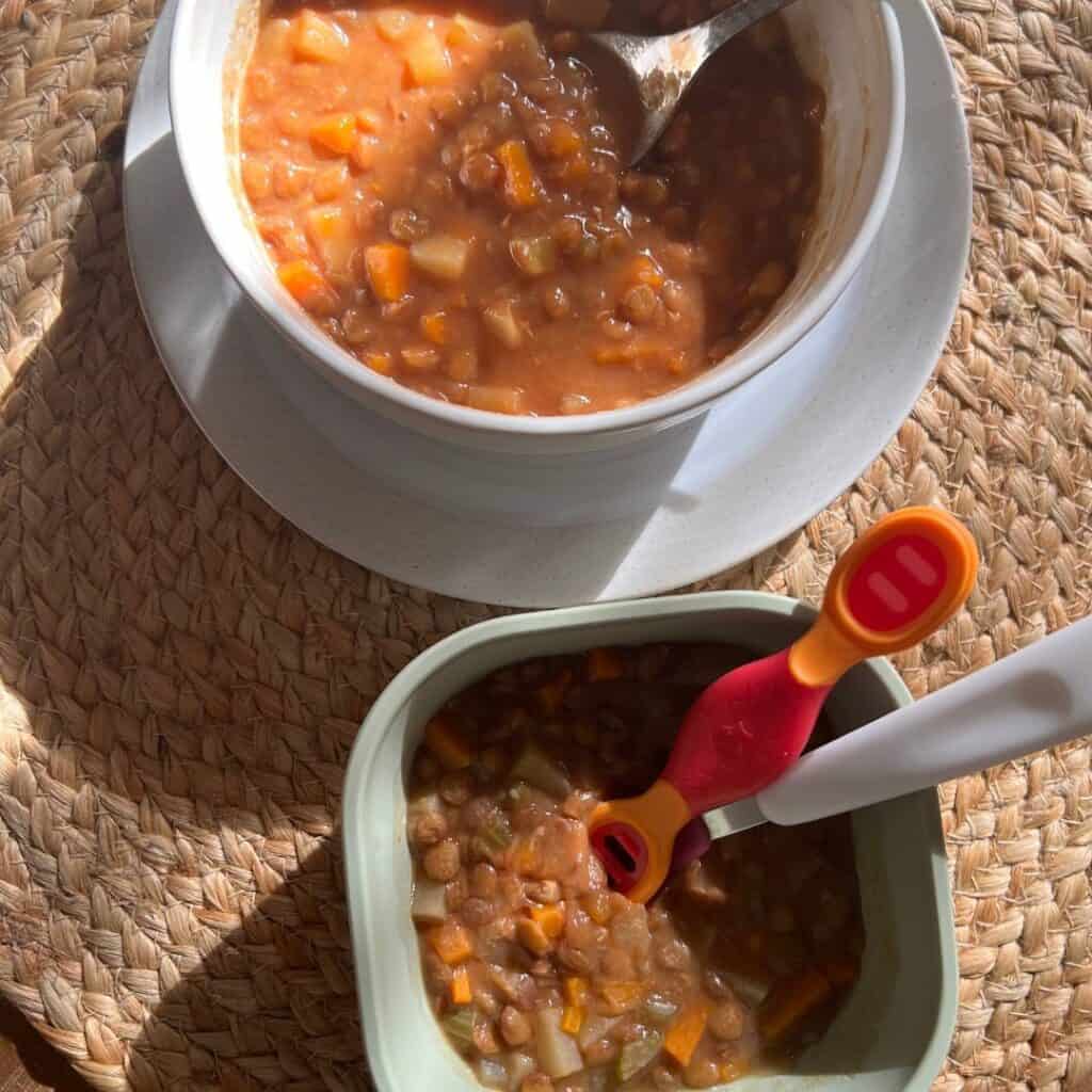 Two bowls of caldo de lentejas - one for an adult and one for a toddler.