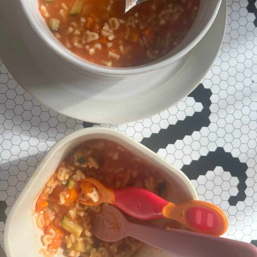 Two bowls of sopita de verduras - one for an adult and one prepped for a baby.