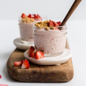 two small mason jars filled with toddler friendly strawberry cheesecake overnight oats for toddlers.
