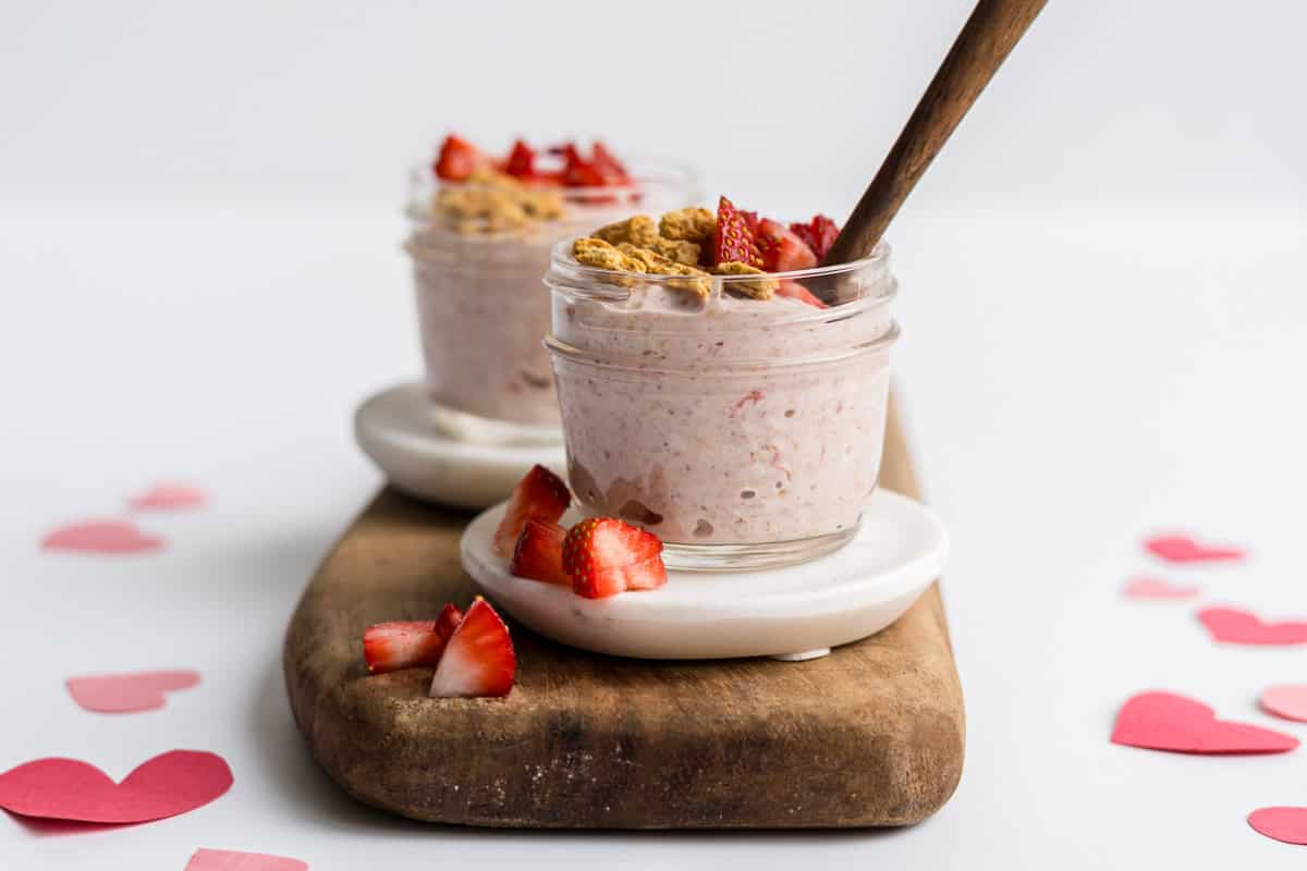 two small mason jars filled with toddler friendly strawberry cheesecake overnight oats for toddlers.