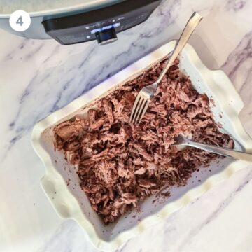 shredded sumac beef in a serving dish with forks 
