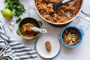 A pot of Sofrito Beef Beans and Rice beside three ways to serve it to a baby - blended, as a rice patty, or for an older baby - as is.