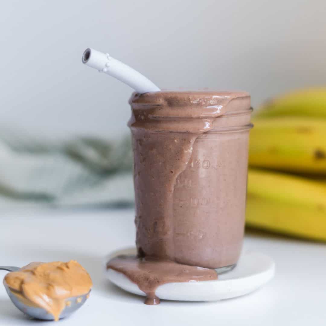 Peanut Butter Banana Smoothie in a small mason jar with a straw