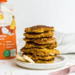 A stack of baby fruit pouch pancakes beside a pouch of Brainiac Neruo+