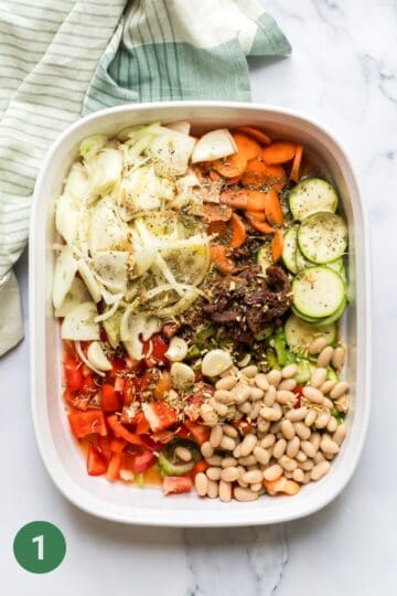 Veggies in casserole dish, ready to be roasted for a baby and toddler friendly pasta sauce.