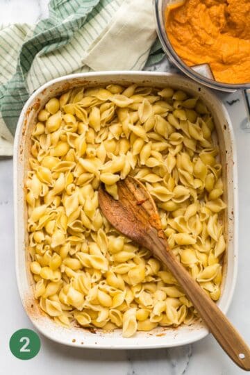 Cooked Pasta in casserole dish ready for the veggie loaded pasta sauce to be poured on top.