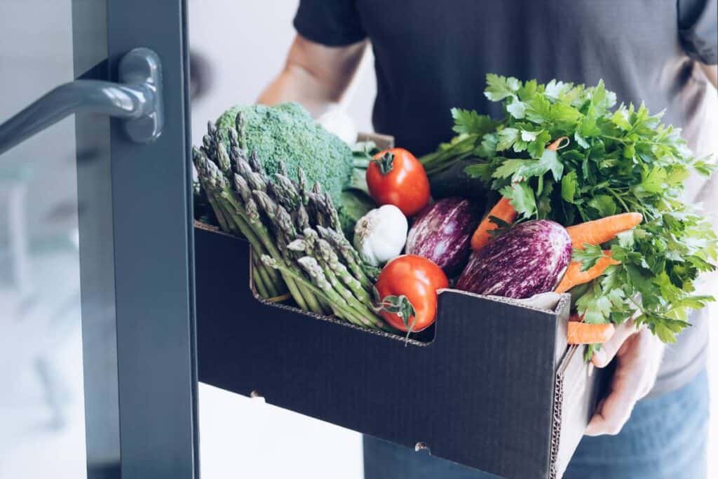A box of produce being delivered to someone's home.