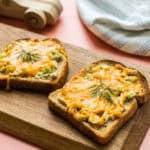 Two ranch tuna melt open faced sandwiches on a serving board.