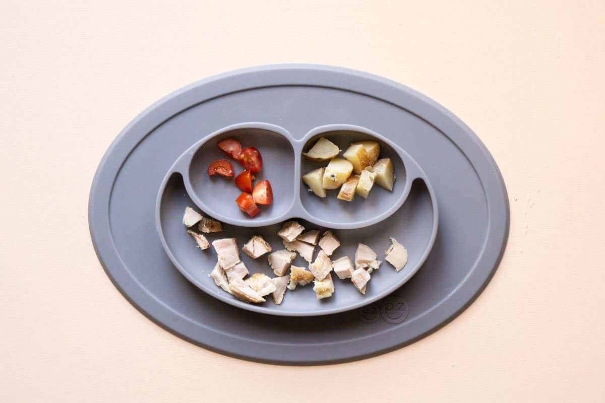 A balanced baby led weaning plate: chicken, potatoes, and tomatoes.