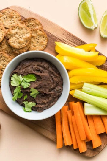 black bean dip on board with veggies and crackers