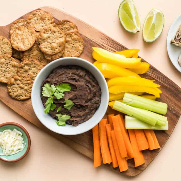 black bean dip on board with veggies and crackers