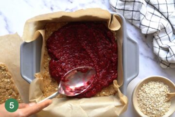 spreading the toddler friendly chia jam onto the base of the healthy breakfast bar recipe for toddlers