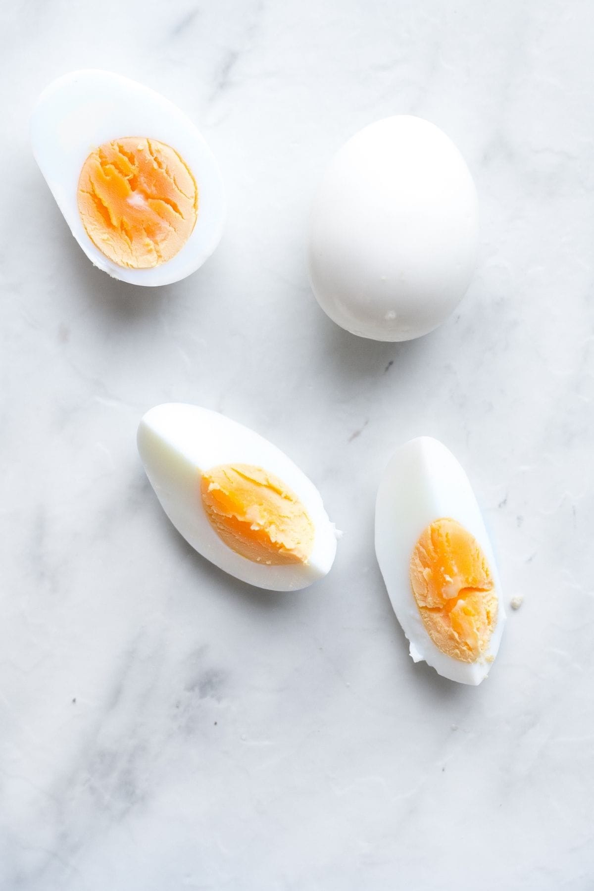 Flat lay of hardboiled eggs that whole, sliced in half and another pair sliced into quarters for baby led weaning. 