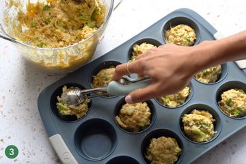 Silicone muffin pan being filled with batter before baking.