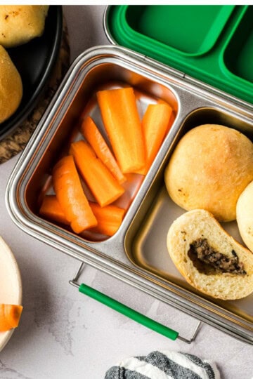 Children's lunch box filled with carrot sticks and Mennonite meat buns.