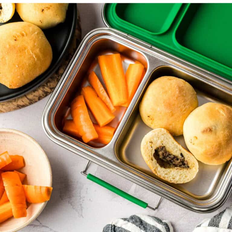 Children's lunch box filled with carrot sticks and Mennonite meat buns.