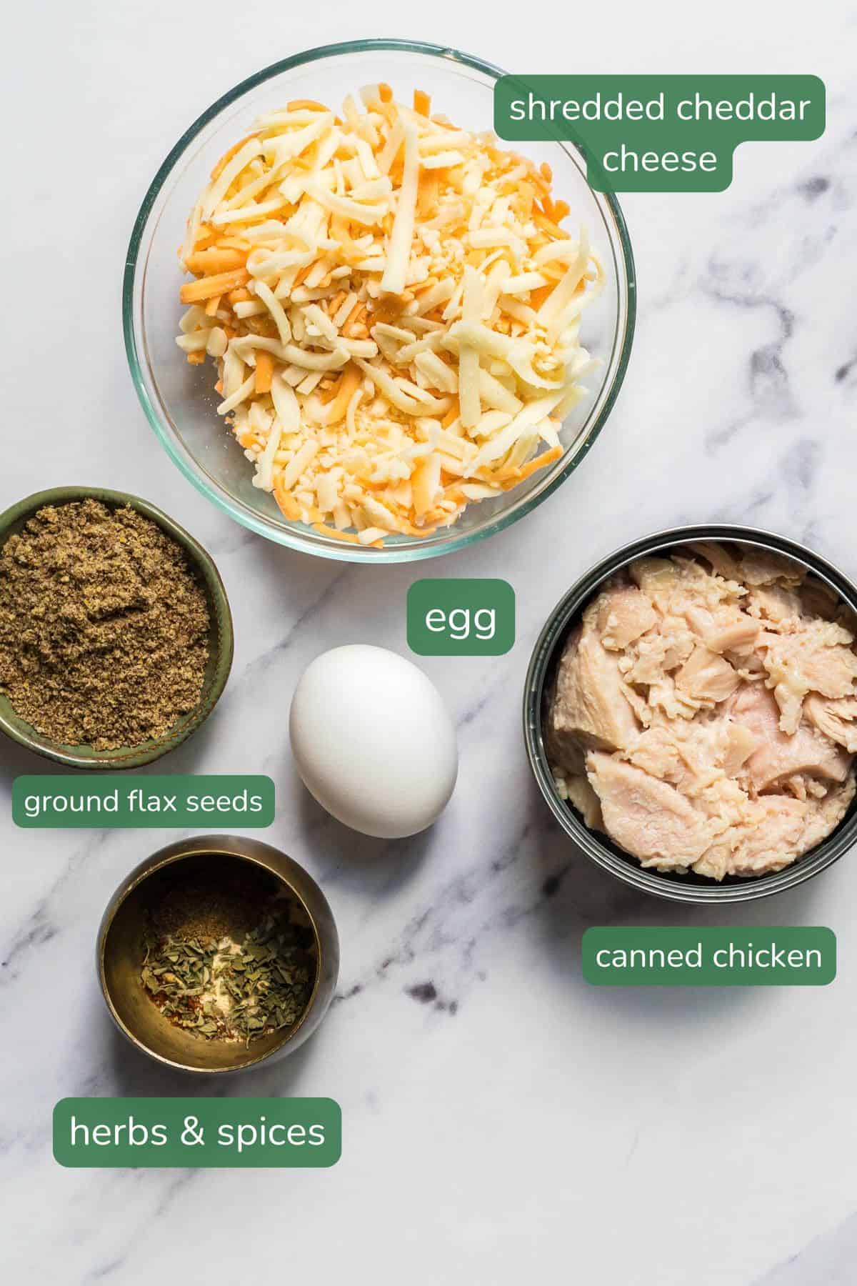 Ingredient laid out for the taco chicken waffles: shredded cheddar cheese, egg, ground flax, canned chicken, herbs and spices. 