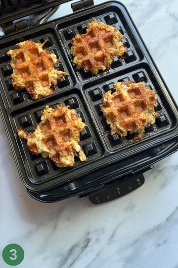 Cooked chicken taco waffles in a waffle iron.