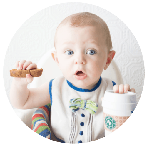 Baby holding pumpkin spice biscotti with Fisher Price Coffee Cup teething toy